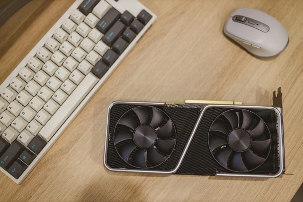 a computer graphics card lying on a desk next to a keyboard and a mouse